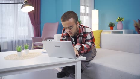 un joven con enanismo trabaja remotamente desde casa con una computadora portátil en línea.