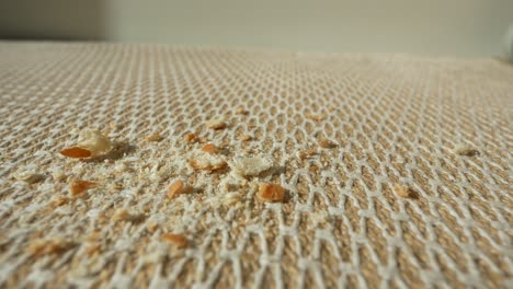 bread crumbs on a beige woven tablecloth