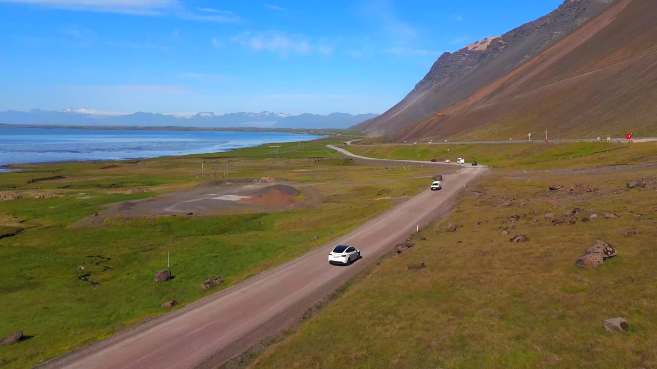 Drone captures a Tesla driving through Iceland’s stunning landscapes, blending modern technology with untouched natural beauty.