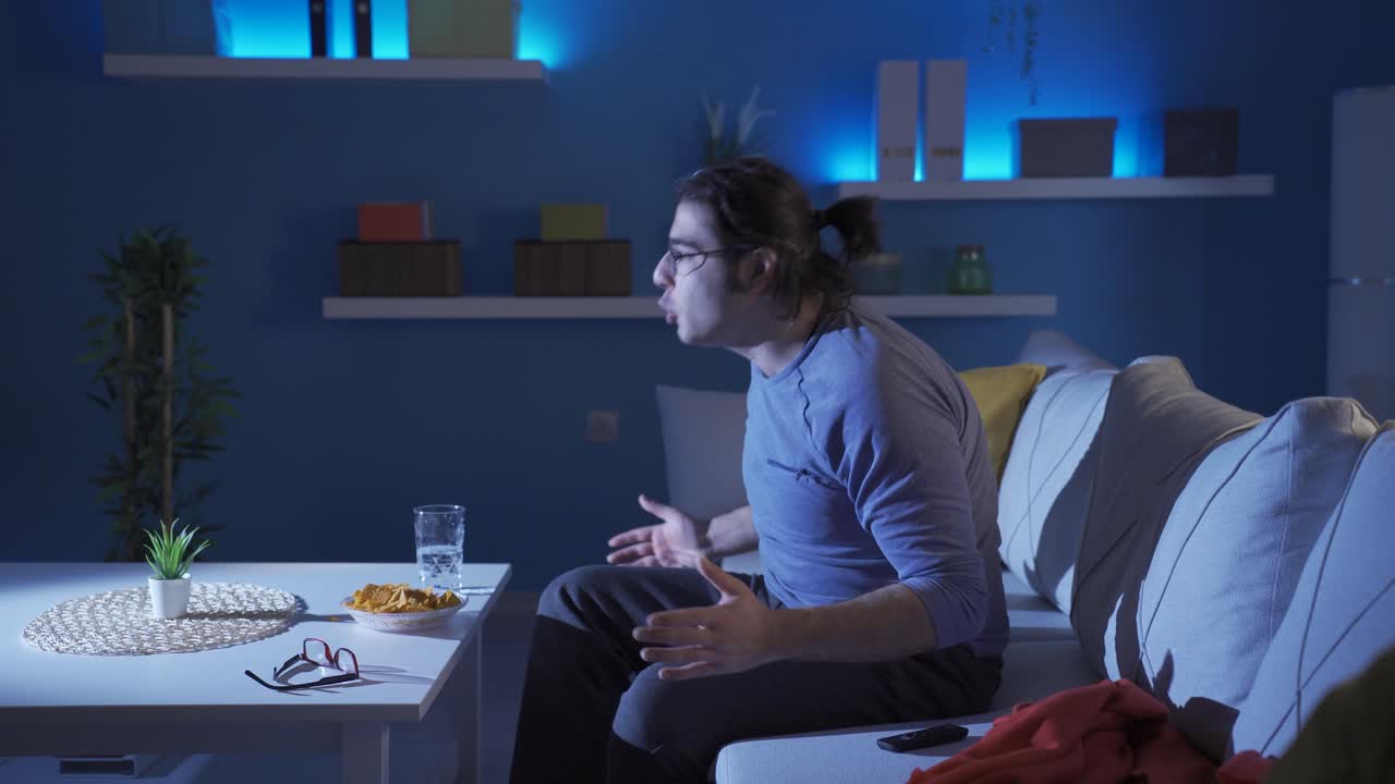 el joven que mira las noticias está enojado.