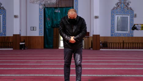 older man prays with mask at mosque