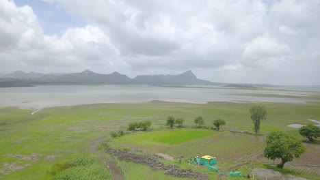 Flooded-Paddy-Fields,-Lake-and-Mountains-in-rural-India,-Aerial