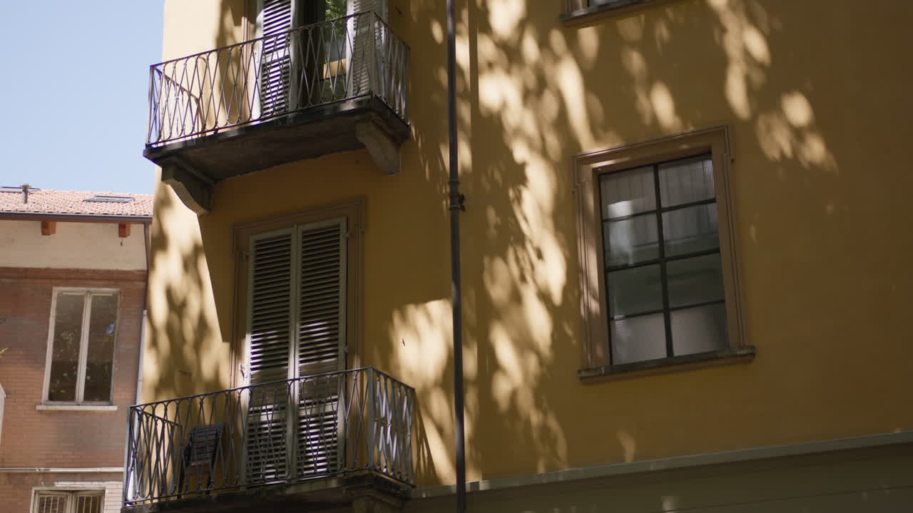 Um edifício amarelo com varandas e janelas