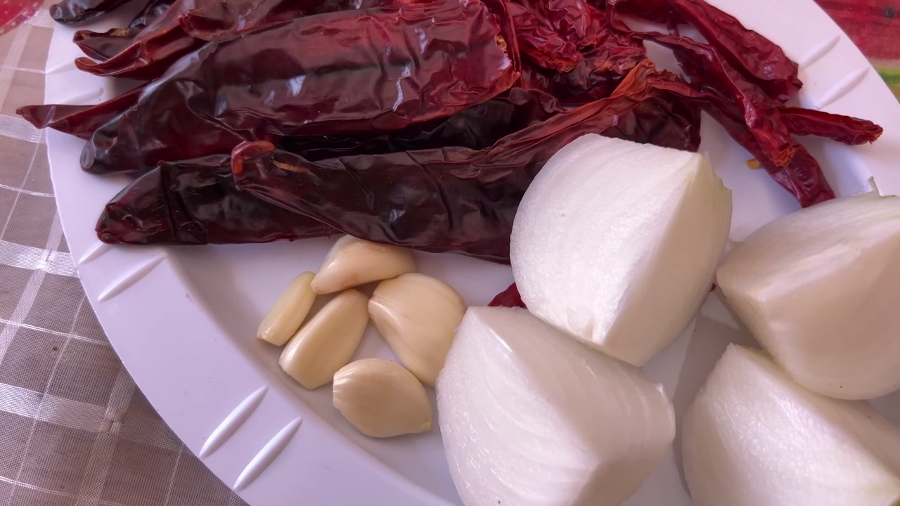 Toma panorámica manual de pimientos rojos secos, ajo y cebollas, listos para la preparación culinaria