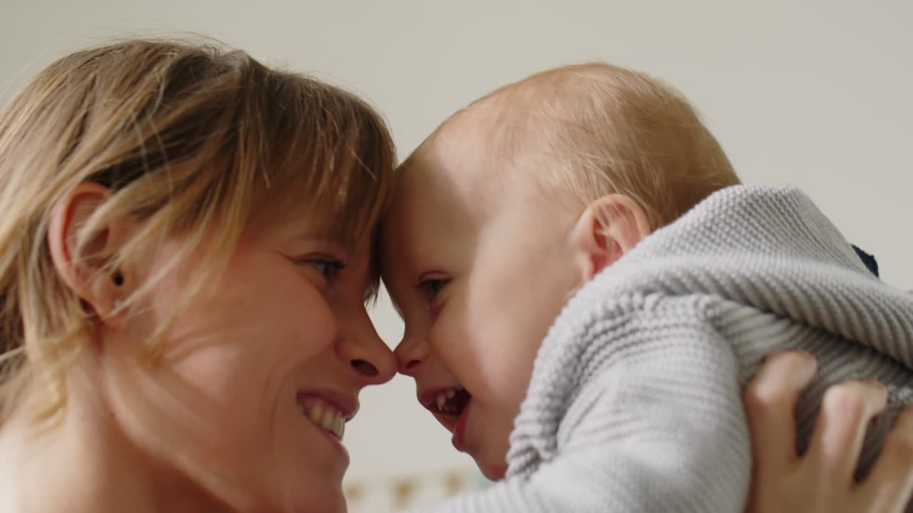 Loving Mother Lifting Happy Baby Son