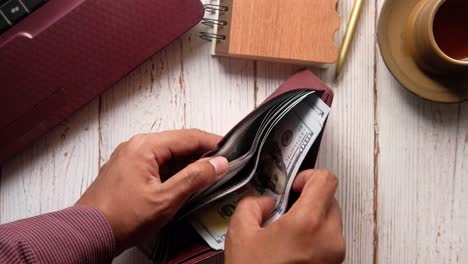 person holding a wallet with cash