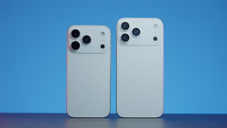 two white smartphones with multiple cameras on a blue background