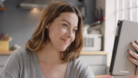beautiful woman talking to friends on internet using digital tablet app at home drinking coffee