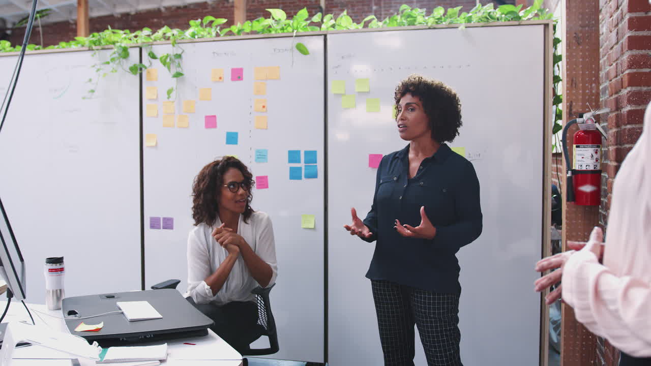 Team creativo femminile in riunione per discutere idee in un ufficio moderno.