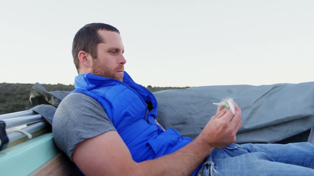 hombre mirando el cebo mientras viaja en barco a motor 4k