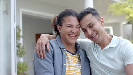 Portrait-of-diverse-gay-male-couple-embracing-and-smiling-in-sunny-garden,-slow-motion