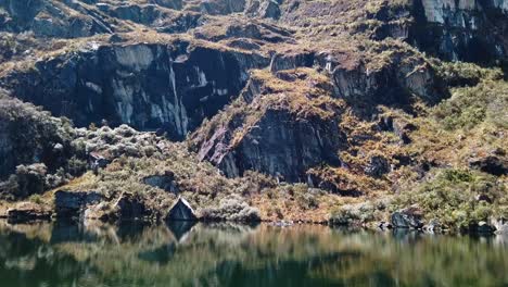 4K-daytime-video-with-a-golden-mountain-side-reflecting-into-the-clear-and-cold-water-of-a-lake-on-the-Lagunas-de-Pichgacocha-in-Ambo,-Huanuco,-Peru