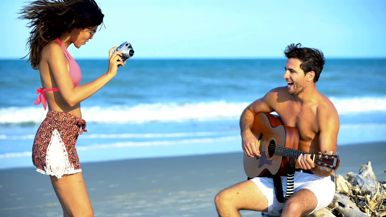 mujer hispana tomando fotos hombre caucásico tocando la guitarra