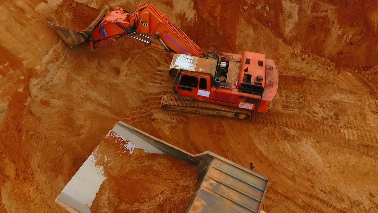 vista desde arriba de la excavadora de minería verter arena en el camión volcador. industria minera