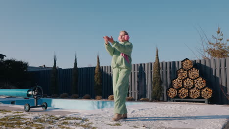 girl playing outdoors in winter near a swimming pool