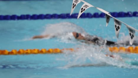 swimmer racing in a pool, showcasing speed and skill