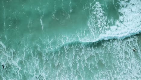 Surfistas-Tratando-De-Atravesar-Fuertes-Olas-Rompientes