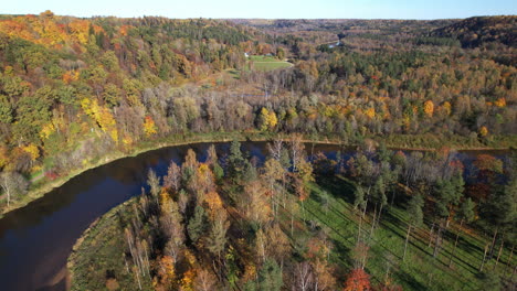 autumn landscape with river bend and colorful foliage in rural area