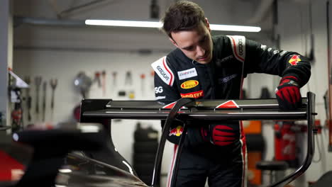 mechanic adjusting the wing of a race car
