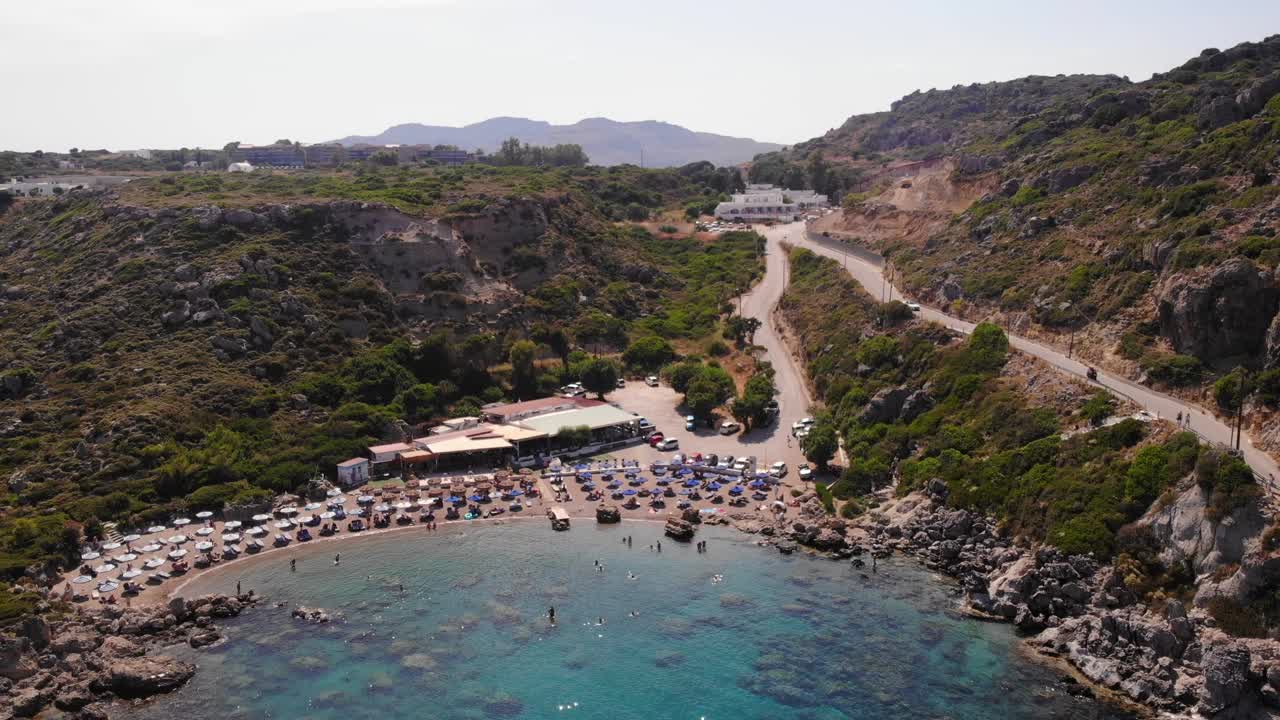birds eye view rising up over anthony quinn bay in rhodes island showing the whole environment with the mountains