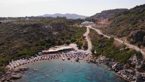 birds eye view rising up over anthony quinn bay in rhodes island showing the whole environment with the mountains