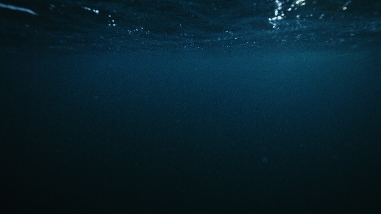Calm underwater Arctic ocean with textured rippling surface above