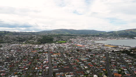 Ein-Stetiger-Drohnenblick-über-Die-Dächer-Der-Häuser-In-Dunedin-City