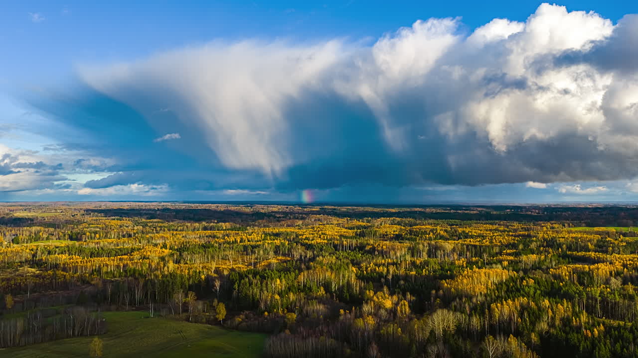 Time lapse rural landscape Latvia large distant rain cloud formation over forest area during autumn