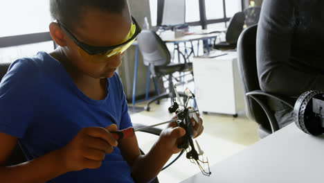 chica reparando un avión no tripulado en el escritorio 4k