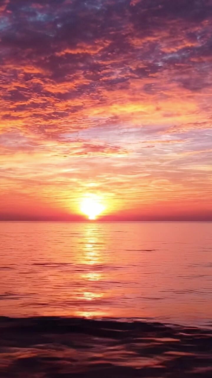 A Breathtaking Sunset Over Calm Waters, with Vibrant Colors Reflecting on the Surface, Illustrating the Beauty of Nature's Evening Palette