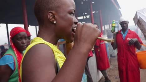 woman eating grilled meat at a busy african market