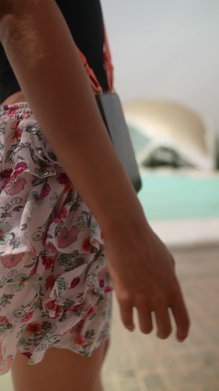 mujer con falda floral y teléfono