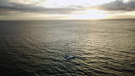 aerial view of catamaran on the pacific ocean, during sunset - tracking, drone shot