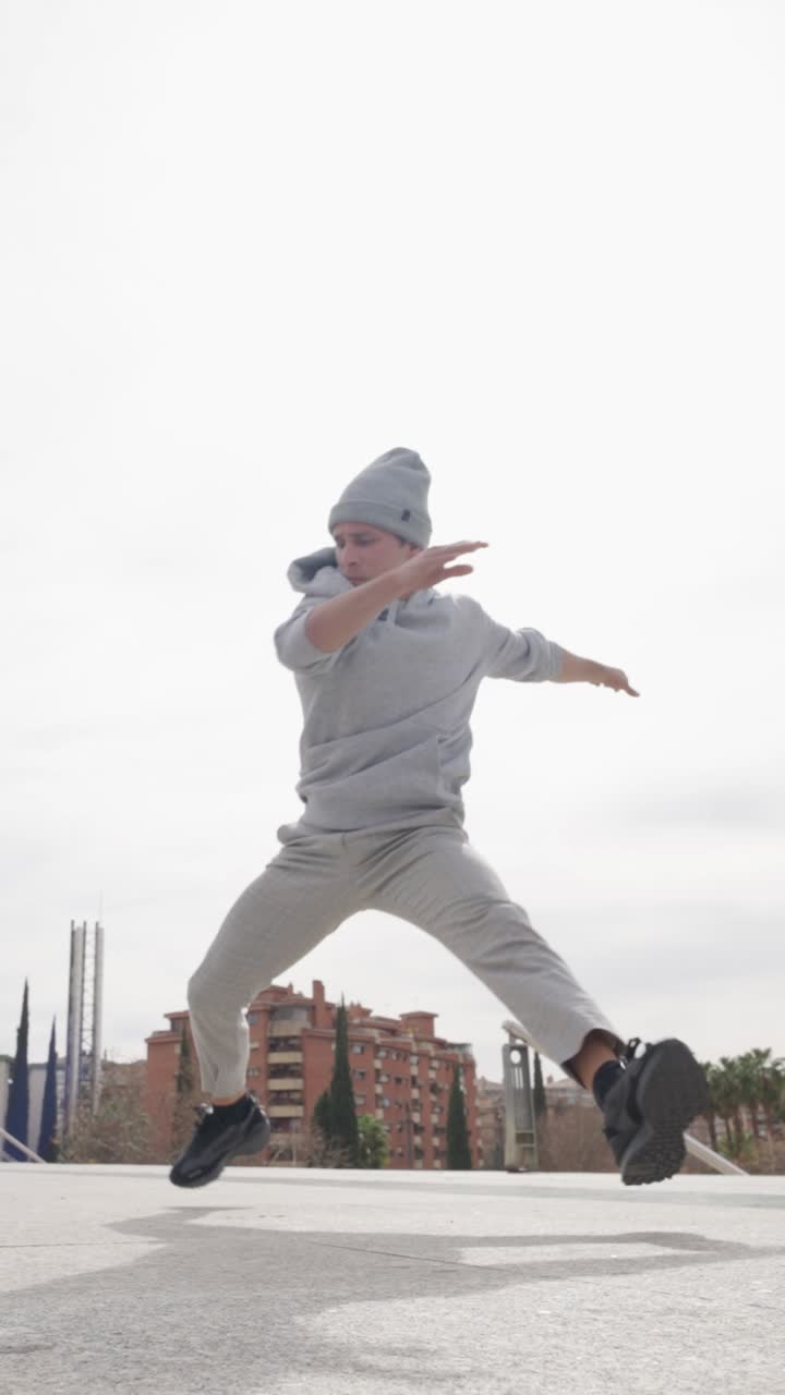 Breakdancer performing cartwheels and posing in urban setting