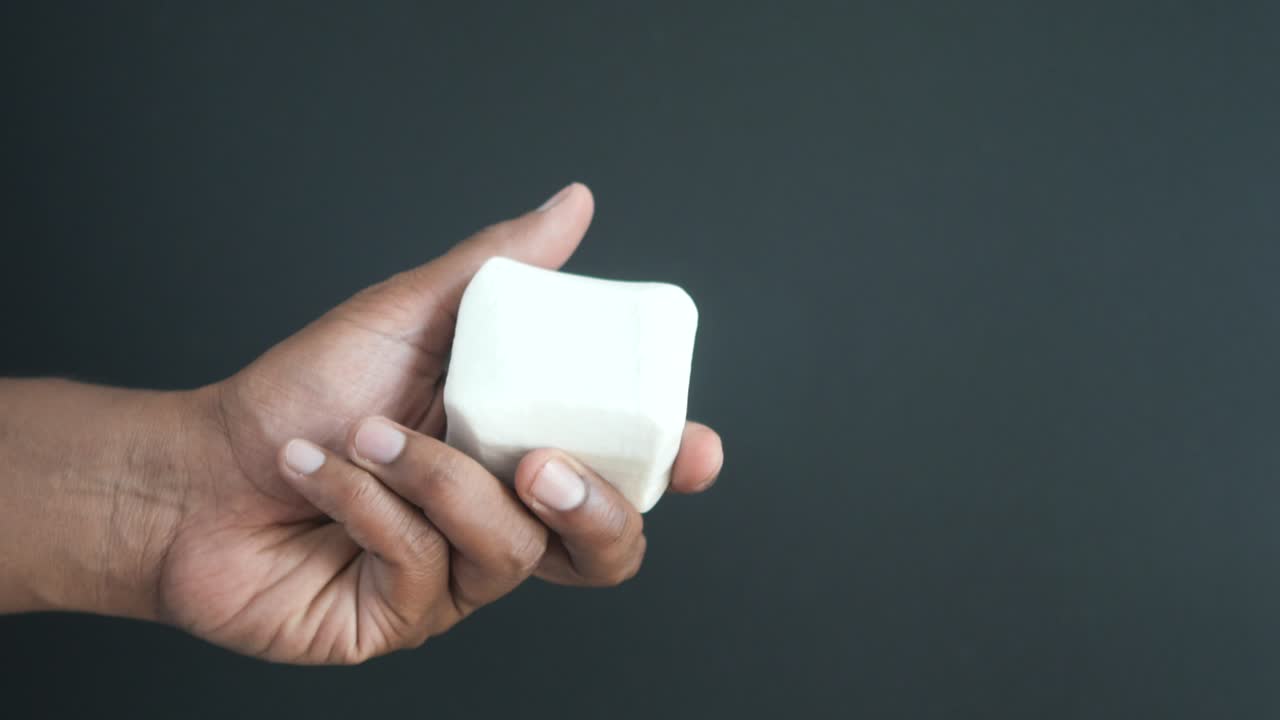 una persona sosteniendo una barra de jabón blanco