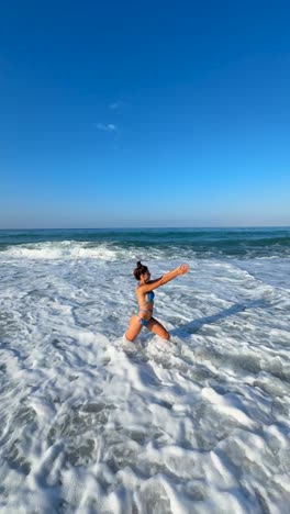 mujer practicando yoga en la playa