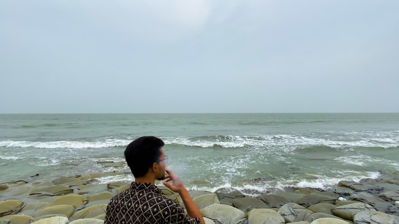 Man Smoking At The Beach - Medium Shot