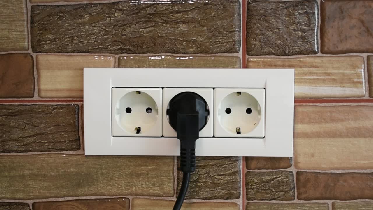 삼중 전원 벽면 소켓에 장치를 연결하는 여성의 손, 중간 위치