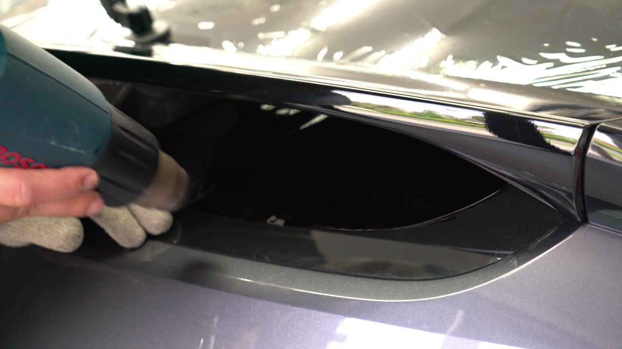 자동차 유리에 틴팅 필름을 설치합니다.