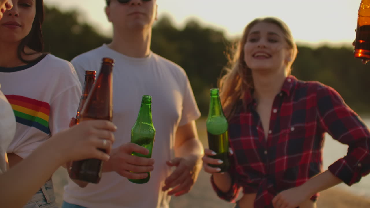 un grupo de jóvenes celebra el final del semestre con cerveza. sonían y bebían cerveza en la fiesta al aire libre.