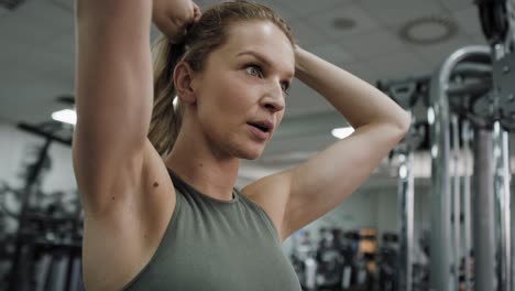 caucasian woman doing dynamic chin ups at the gym.