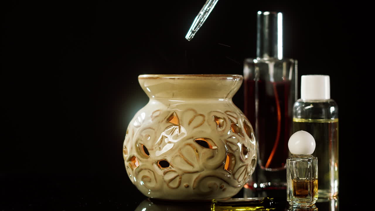 Huile essentielle versée dans un diffuseur d’aromathérapie en céramique