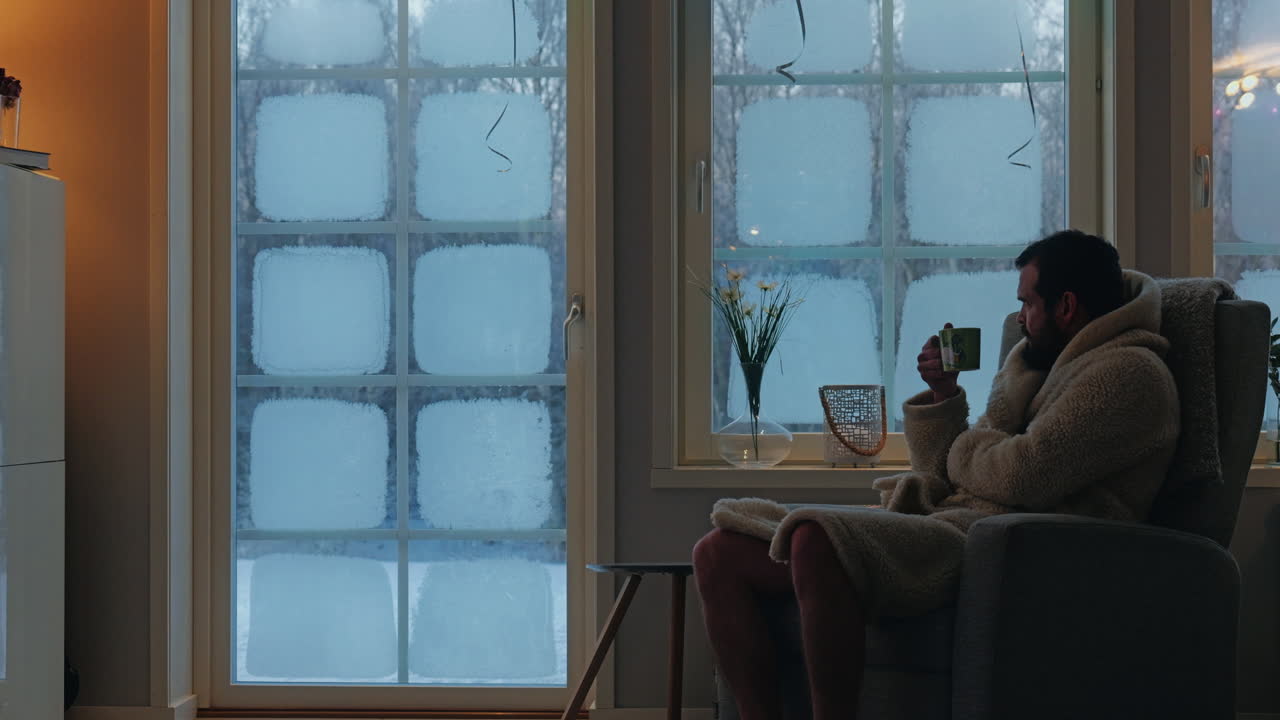 Freezing man in bathrobe drinking hot beverage when its cold outside