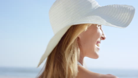 Close-up-of-beautiful-woman-walking-on-beach-looking-back-at-camera-smiling-steadicam-slow-motion-shot