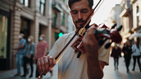 man playing violin on city street