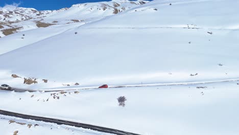 snowy mountain road with a vehicle