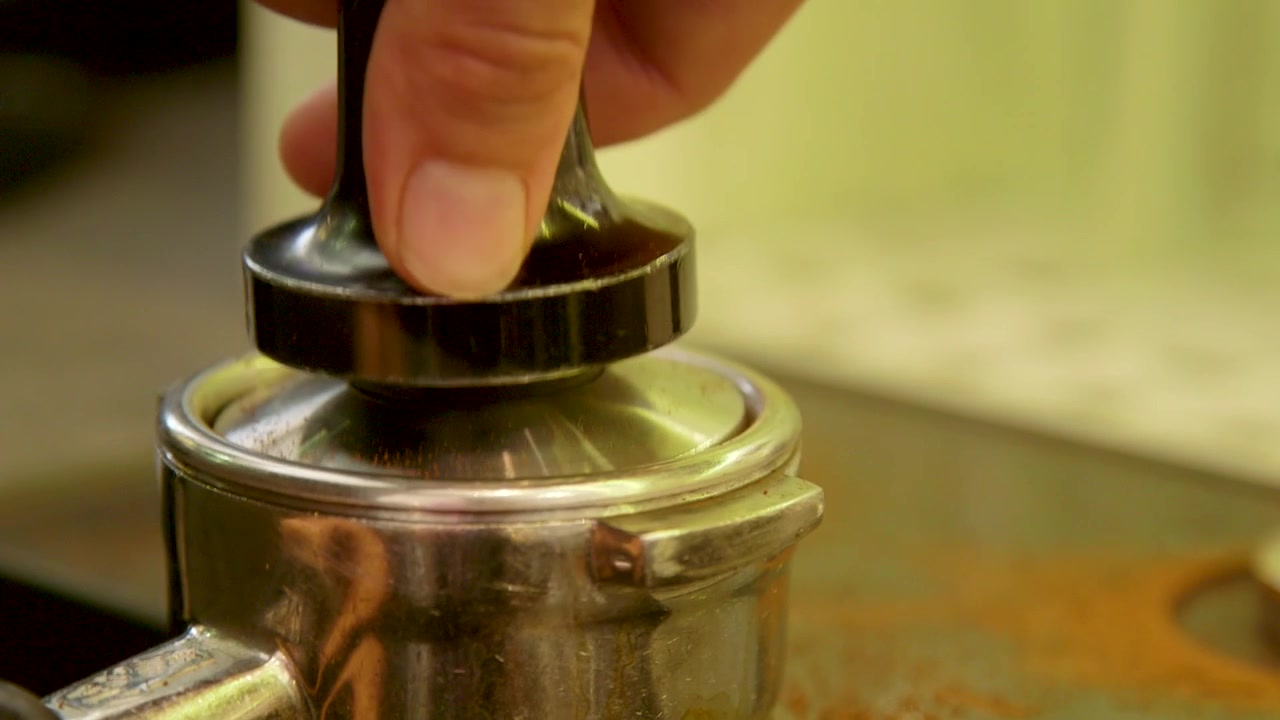 how to make a real Italian espresso:
footage of barista pressing the ground coffee powder into the filter