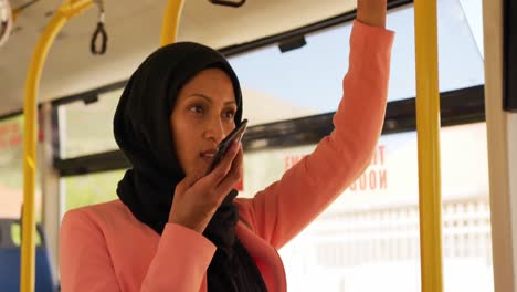 young woman wearing hijab commuting on a bus