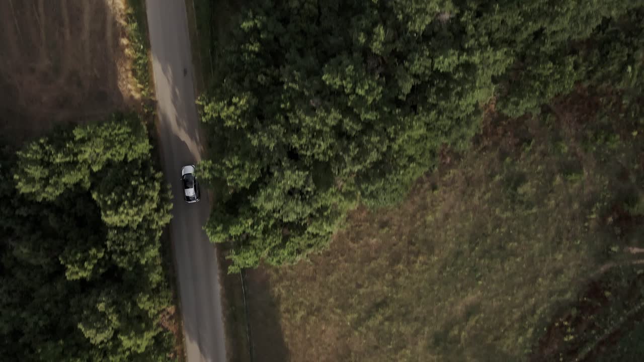 Vista aerea dall'alto di un'auto grigia che guida su una strada di campagna in Provenza, Francia