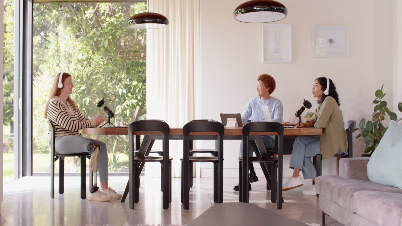 Recording podcast, diverse female friends sitting at table with microphones and headphones, copy spa
